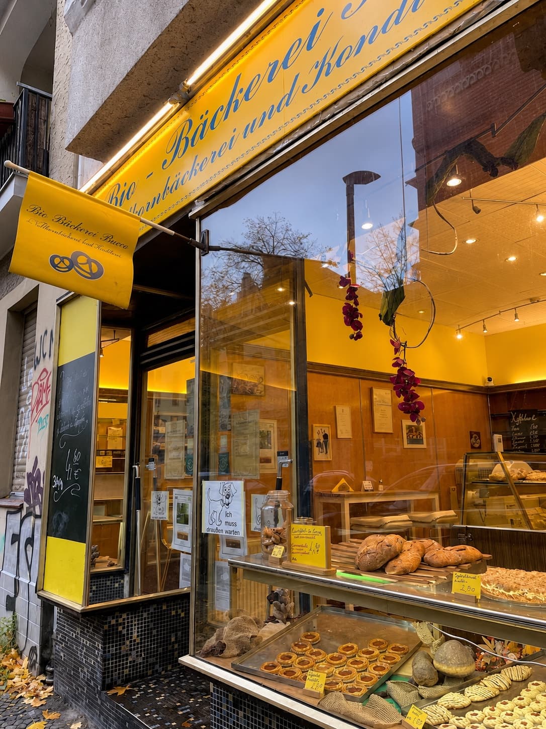 Echter Laden der Bio-Bäckerei Bucco mit gelber Fassade und Auslage